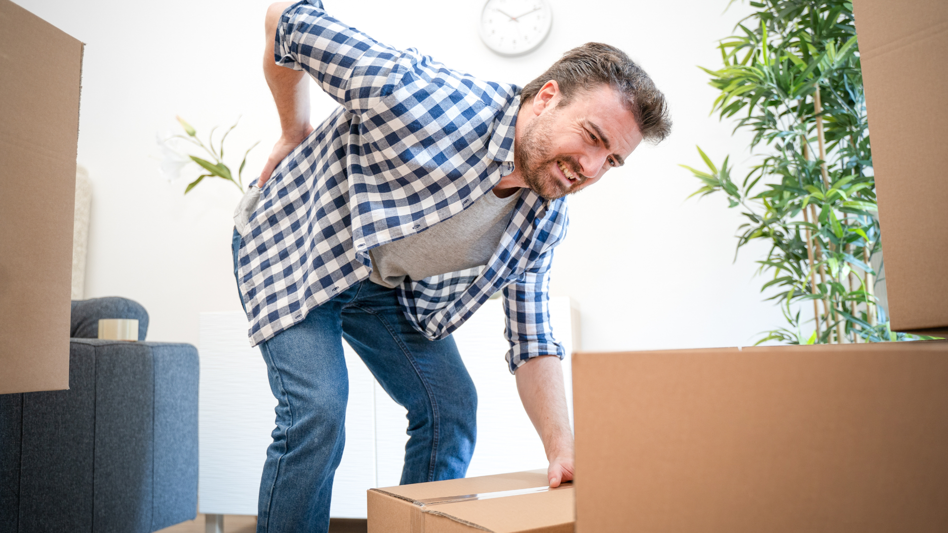 Man feeling back ache cramp lifting heavy boxes