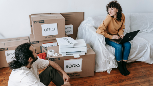 Couple sitting beside packed boxes