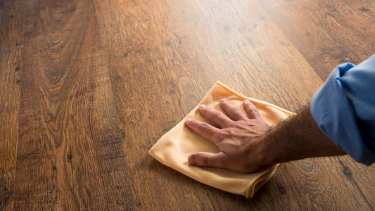 Man wiping hardwood flooring