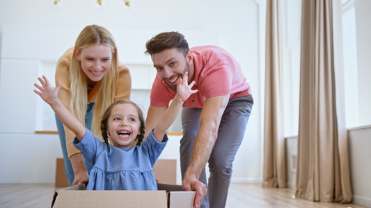 Mom and Dad playing with their little daughter while inside the box