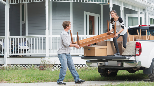 Young couple moving furniture into new home