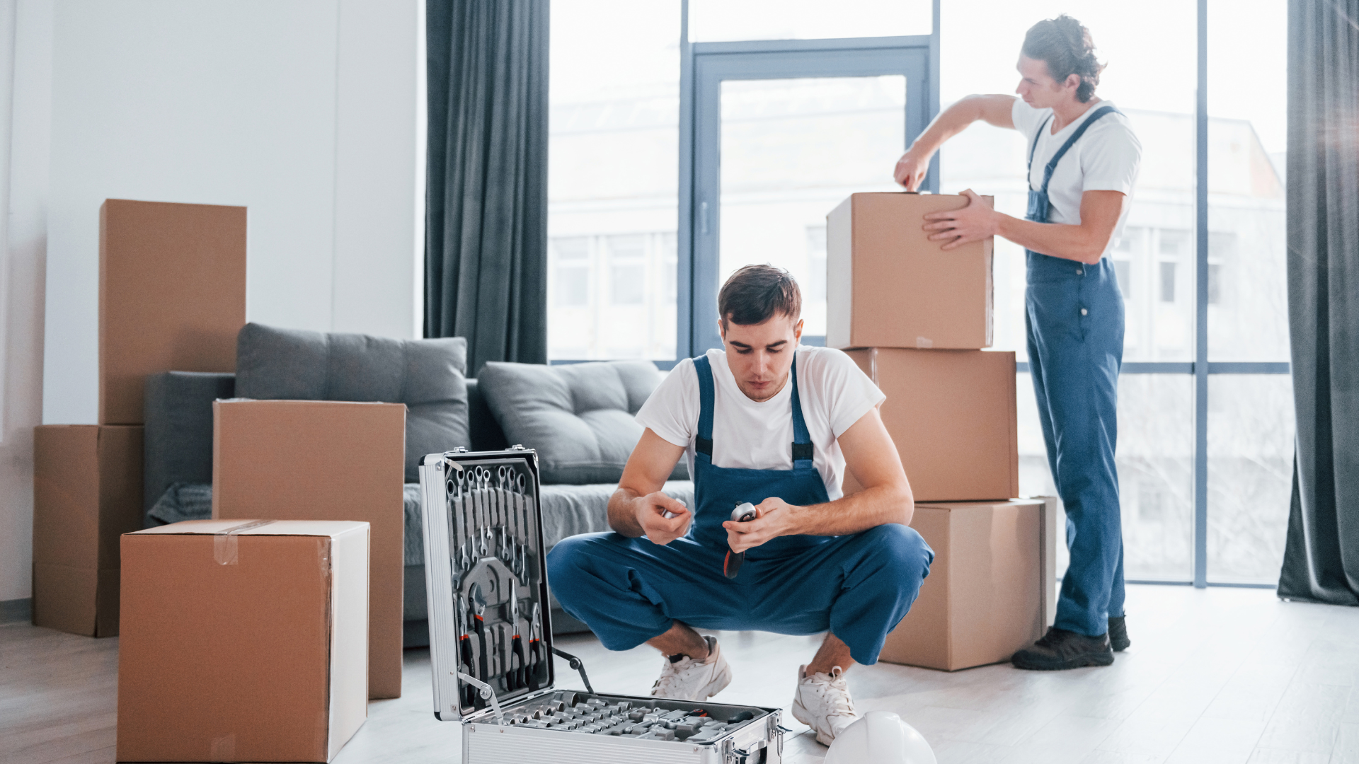 Two movers packing stuff inside the house 